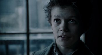 Movie still from “Sweeney Todd: The Demon Barber of Fleet Street” (2007), directed by Tim Burton – A person with short brown hair is looking out a window; Close Up shot, Low angle