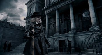 Movie still from “Sweeney Todd: The Demon Barber of Fleet Street” (2007), directed by Tim Burton – An old woman with a hat and a cane in front of an old building; Medium shot, Low angle