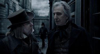 Movie still from “Sweeney Todd: The Demon Barber of Fleet Street” (2007), directed by Tim Burton – Two men are standing in the street talking to each other; Close Up shot, Over the shoulder angle