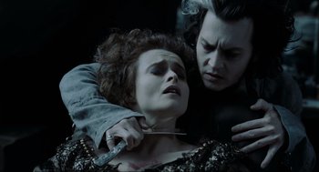 Movie still from “Sweeney Todd: The Demon Barber of Fleet Street” (2007), directed by Tim Burton – A man and a woman are holding a knife; Close Up shot, High angle