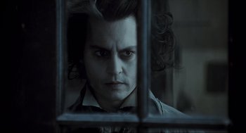 Movie still from “Sweeney Todd: The Demon Barber of Fleet Street” (2007), directed by Tim Burton – Johnny depp as sweeney todd looking through the bars of a jail cell; Close Up shot, Over the shoulder angle