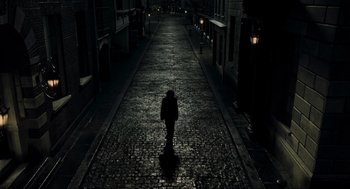 Movie still from “Sweeney Todd: The Demon Barber of Fleet Street” (2007), directed by Tim Burton – A person walking down a street at night; Extreme Wide shot, High angle