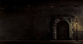Movie still from “Sweeney Todd: The Demon Barber of Fleet Street” (2007), directed by Tim Burton – A person walking in front of a brick wall; Extreme Wide shot, Low angle