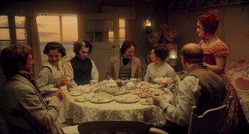 Movie still from “Sweeney Todd: The Demon Barber of Fleet Street” (2007), directed by Tim Burton – A group of people sitting around a table; Medium shot, High angle