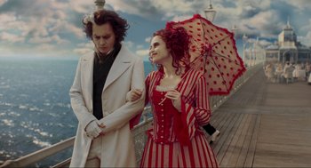 Movie still from “Sweeney Todd: The Demon Barber of Fleet Street” (2007), directed by Tim Burton – A man and a woman walking on a pier with an umbrella; Medium shot, Low angle