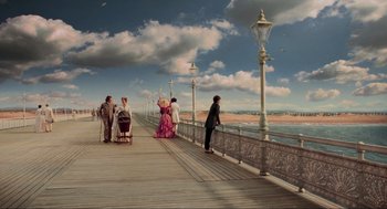 Movie still from “Sweeney Todd: The Demon Barber of Fleet Street” (2007), directed by Tim Burton – A group of people standing on a pier near a body of water; Extreme Wide shot, Low angle