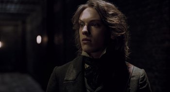 Movie still from “Sweeney Todd: The Demon Barber of Fleet Street” (2007), directed by Tim Burton – A man with long brown hair wearing a suit and tie; Close Up shot, Low angle