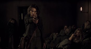 Movie still from “Sweeney Todd: The Demon Barber of Fleet Street” (2007), directed by Tim Burton – A woman holding a gun while standing in a room; Medium shot, Over the shoulder angle