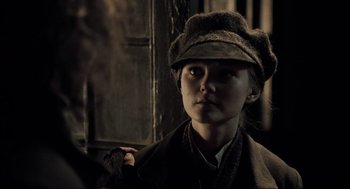 Movie still from “Sweeney Todd: The Demon Barber of Fleet Street” (2007), directed by Tim Burton – A woman wearing a hat and a coat; Close Up shot, Over the shoulder angle
