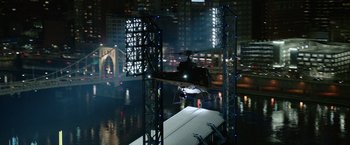 Movie still from “Sweet Girl” (2021), directed by Brian Andrew Mendoza – A helicopter is flying over a river at night; Extreme Wide shot, High angle