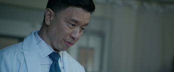 Movie still from “Sweet Girl” (2021), directed by Brian Andrew Mendoza – A person wearing a suit and a tie; Close Up shot, Low angle