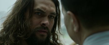 Movie still from “Sweet Girl” (2021), directed by Brian Andrew Mendoza – A man with long hair and a beard stares at another man with long hair; Close Up shot, Over the shoulder angle