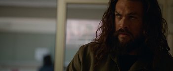 Movie still from “Sweet Girl” (2021), directed by Brian Andrew Mendoza – A person with long hair and a beard; Close Up shot, Over the shoulder angle