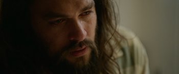 Movie still from “Sweet Girl” (2021), directed by Brian Andrew Mendoza – A person with long hair and a beard; Close Up shot, Over the shoulder angle