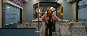 Movie still from “Sweet Girl” (2021), directed by Brian Andrew Mendoza – A woman standing on a train looking at the camera; Medium shot, Low angle