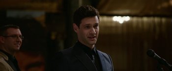 Movie still from “Sweet Girl” (2021), directed by Brian Andrew Mendoza – A person wearing a suit and tie; Close Up shot, Over the shoulder angle