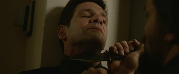 Movie still from “Sweet Girl” (2021), directed by Brian Andrew Mendoza – A man holding a pair of scissors up to his face; Close Up shot, Low angle