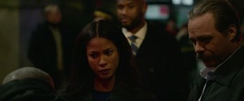 Movie still from “Sweet Girl” (2021), directed by Brian Andrew Mendoza – A woman standing next to a man wearing a suit and tie; Close Up shot, Over the shoulder angle