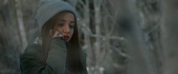 Movie still from “Sweet Girl” (2021), directed by Brian Andrew Mendoza – A woman in a hat is talking on a cell phone; Close Up shot, High angle