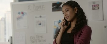 Movie still from “Sweet Girl” (2021), directed by Brian Andrew Mendoza – A woman talking on a cell phone while standing in front of a whiteboard; Close Up shot, Low angle