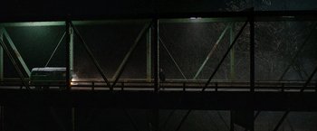 Movie still from “Sweet Girl” (2021), directed by Brian Andrew Mendoza – A person is standing on a bridge at night; Extreme Wide shot, High angle