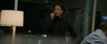 Movie still from “Sweet Girl” (2021), directed by Brian Andrew Mendoza – A woman talking on a phone while wearing a black jacket; Medium shot, Over the shoulder angle