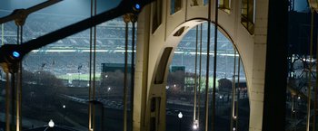 Movie still from “Sweet Girl” (2021), directed by Brian Andrew Mendoza – A view of a stadium from a bridge at night time; Extreme Wide shot, High angle