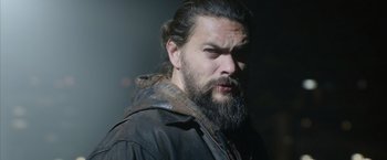 Movie still from “Sweet Girl” (2021), directed by Brian Andrew Mendoza – A man with long hair and a long beard; Close Up shot, Low angle