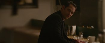 Movie still from “Sweet Girl” (2021), directed by Brian Andrew Mendoza – A man sitting at a table in front of a glass of water; Close Up shot, Over the shoulder angle