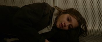 Movie still from “Sweet Girl” (2021), directed by Brian Andrew Mendoza – A woman laying on the ground with her head on her pillow; Close Up shot, Overhead angle