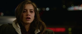Movie still from “Sweet Girl” (2021), directed by Brian Andrew Mendoza – A young woman with long brown hair is looking at the camera; Close Up shot, Over the shoulder angle