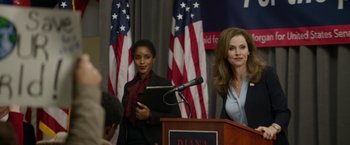Movie still from “Sweet Girl” (2021), directed by Brian Andrew Mendoza – Two women standing in front of a podium with microphones; Medium shot, Over the shoulder angle