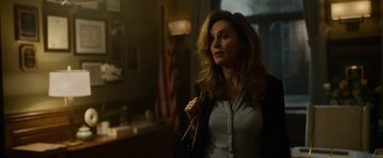 Movie still from “Sweet Girl” (2021), directed by Brian Andrew Mendoza – A woman holding a purse while standing in a room; Medium shot, Over the shoulder angle