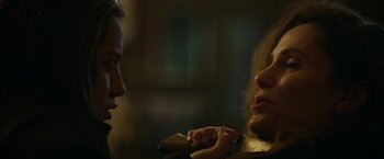 Movie still from “Sweet Girl” (2021), directed by Brian Andrew Mendoza – A woman holding a cell phone in front of another woman; Close Up shot, Over the shoulder angle