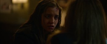 Movie still from “Sweet Girl” (2021), directed by Brian Andrew Mendoza – A young woman with a bruised face stares into the camera; Close Up shot, Over the shoulder angle