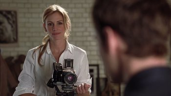 Movie still from “Closer” (2004), directed by Mike Nichols – A woman holding a camera in front of a mirror; Close Up shot, Over the shoulder angle