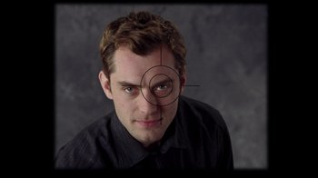 Movie still from “Closer” (2004), directed by Mike Nichols – A young man with a fake eye in front of a gray background; Extreme Close Up shot, Overhead angle