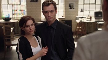 Movie still from “Closer” (2004), directed by Mike Nichols – A man and a woman standing next to each other in a room; Medium shot, Over the shoulder angle