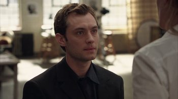 Movie still from “Closer” (2004), directed by Mike Nichols – A man wearing a suit and tie looking to his left; Close Up shot, Over the shoulder angle