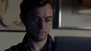 Movie still from “Closer” (2004), directed by Mike Nichols – A man with glasses is looking at a laptop; Close Up shot, Over the shoulder angle