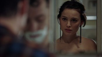 Movie still from “Closer” (2004), directed by Mike Nichols – A woman looking in a mirror with a man in the background; Close Up shot, Over the shoulder angle