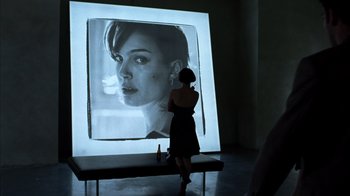 Movie still from “Closer” (2004), directed by Mike Nichols – A woman standing in front of an image of a woman; Medium shot, Over the shoulder angle