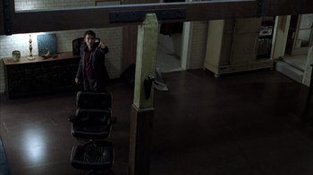 Movie still from “Closer” (2004), directed by Mike Nichols – A man in a suit and tie standing in a room; Wide shot, High angle