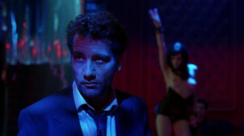 Movie still from “Closer” (2004), directed by Mike Nichols – A man in a suit standing next to a woman in a bikini; Close Up shot, Low angle