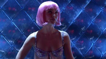 Movie still from “Closer” (2004), directed by Mike Nichols – A woman in a pink wig posing for a picture; Close Up shot, Low angle