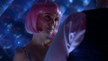 Movie still from “Closer” (2004), directed by Mike Nichols – A woman with a pink wig is standing in front of a mirror; Close Up shot, Over the shoulder angle