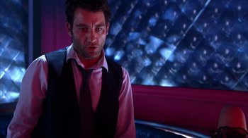 Movie still from “Closer” (2004), directed by Mike Nichols – A man wearing a vest and a pink shirt; Medium shot, Over the shoulder angle