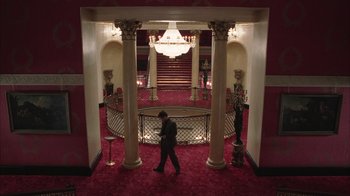 Movie still from “Closer” (2004), directed by Mike Nichols – A man walking through a hall way in a building; Extreme Wide shot, High angle