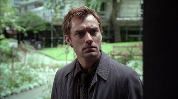 Movie still from “Closer” (2004), directed by Mike Nichols – A person wearing a jacket and tie; Close Up shot, Low angle