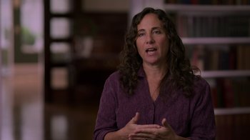Movie still from “Take Your Pills: Xanax” (2022), directed by Blair Foster – A woman in a purple shirt is talking to someone; Medium shot, Over the shoulder angle